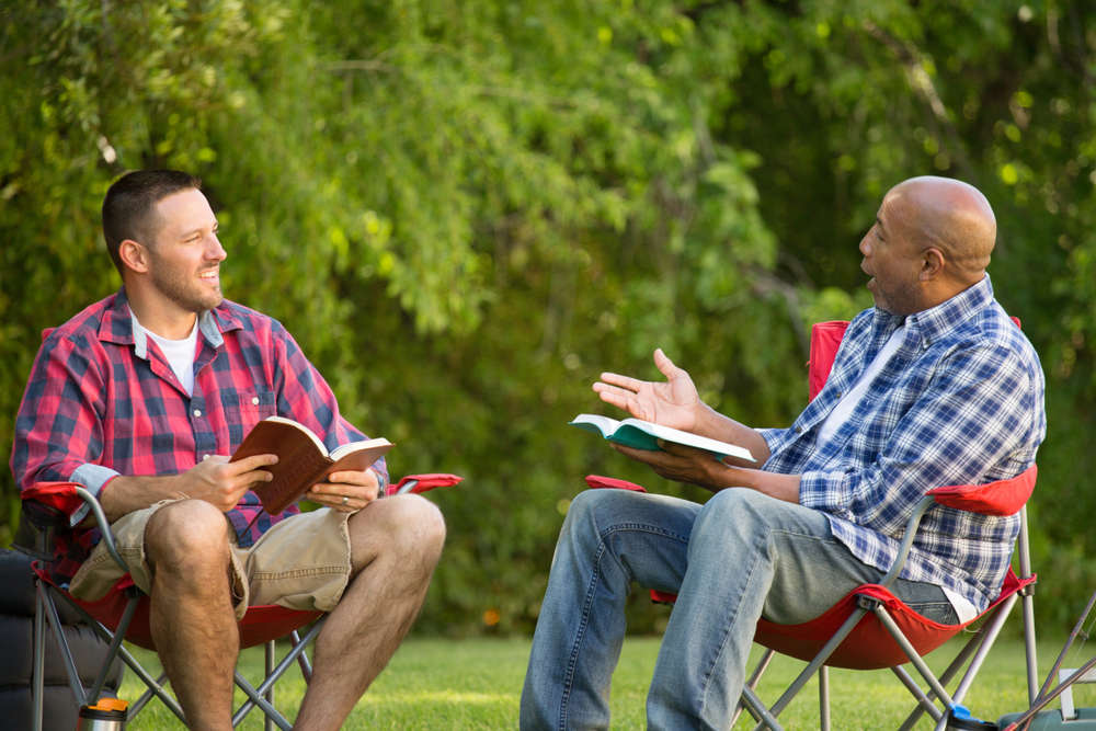 Men,Having,A,Bible,Study,On,A,Camping,Trip.